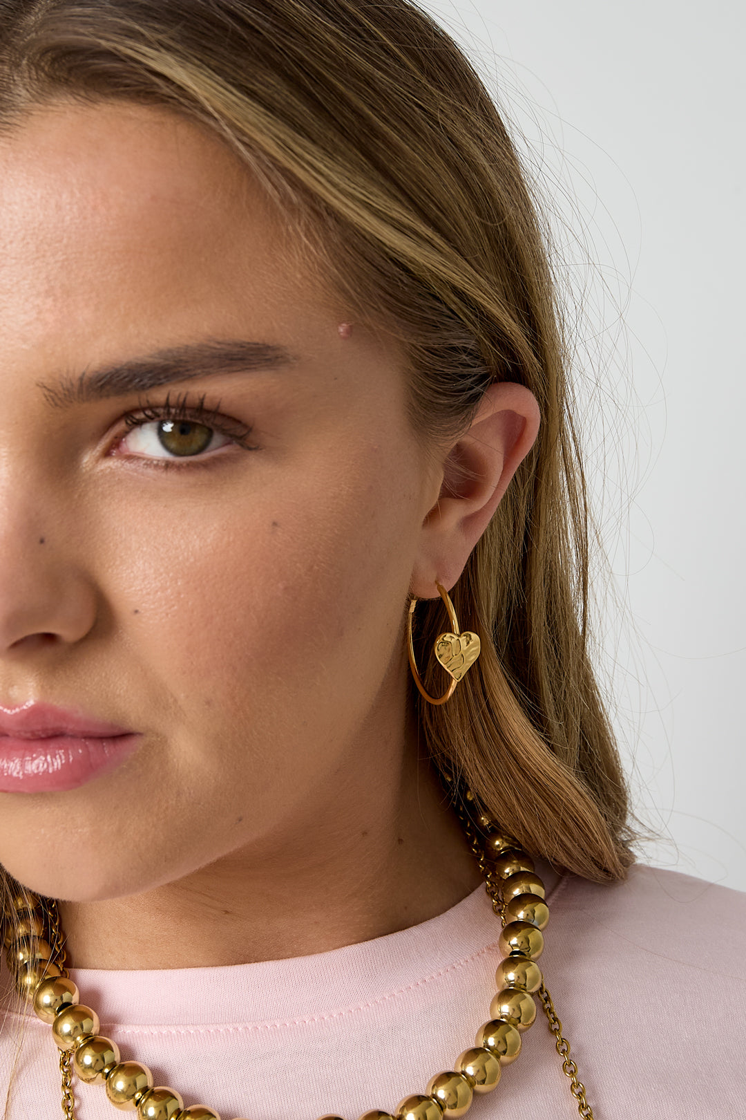 Damen trägt Creolen mit Herz im romantischen und modernen Look