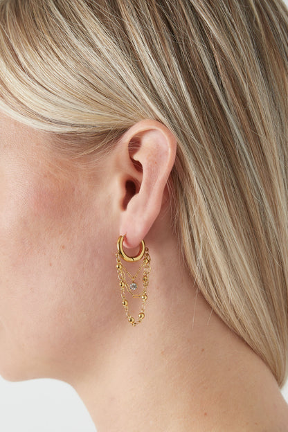 Seitenansicht der goldfarbenen Ohrringe mit dekorativer Kette für Damen.